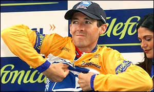 Roberto Heras pulls on the overall leader's yellow jersey