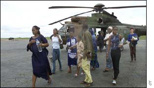 Evacuees leaving a rescue helicopter at the Yamoussoukro airport 
