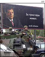 Soldiers stand in front a billboard for Mr Kostunica