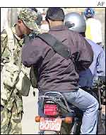 Soldier checks motorcyclists during strike