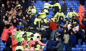 Stewards try to keep the battling rival fans apart