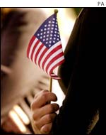 Mourner holds a US flag outside a British 9/11 memorial