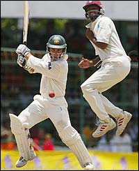 Australia's Justin Langer hits out forcing West Indies fielder Darren Ganga to take evasive action