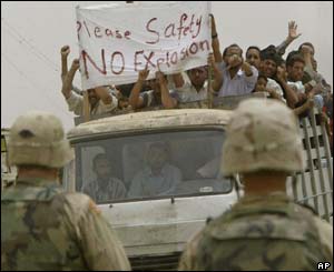 Iraqi mourners, leading a procession with coffins carrying the dead, protest in front of American soldiers 