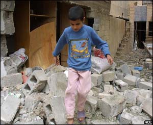 An Iraqi child walks amid the rubble of the destroyed houses 