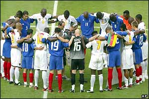 The French and Cameroon players in a circle for the minute's silence