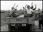 Prisoners wave goodbye from back of a truck