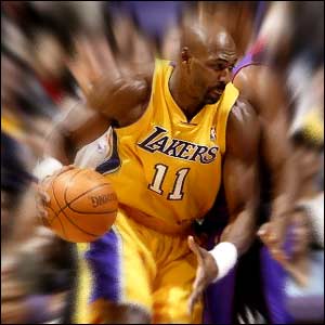 Karl Malone of the Los Angeles Lakers evades Jerome Williams of the Toronto Raptors
