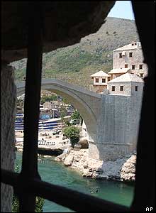 The Old Bridge is seen on Friday through the ruins of a nearby house 