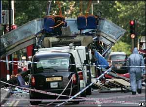 A forensic officer searches the wreckage of a double-decker bus with its top blown off at Tavistock Square in central London 