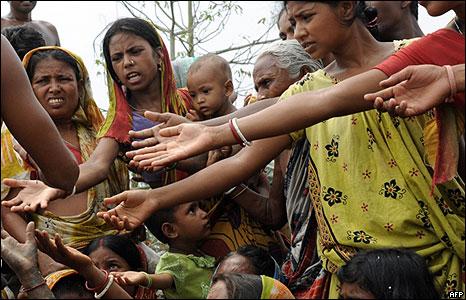 Indian villagers reach for food during distribution by a social welfare group at Kumirmari village in the Sunderbans, the world"s biggest mangrove reserve, 170 kms south of Calcutta on June 3, 2009