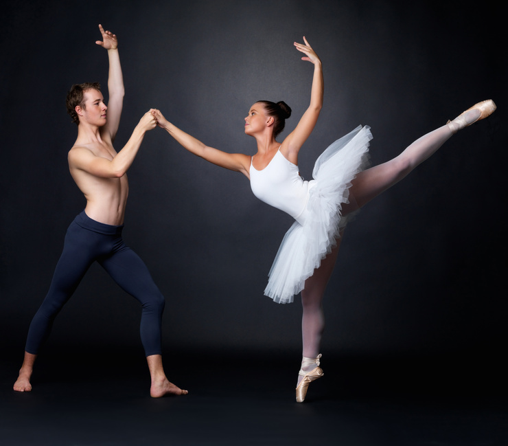 Two graceful ballet dancers performing against black background @ Yuri Arcurs - fotolia.com