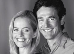 A smiling couple, showing perfect teeth.