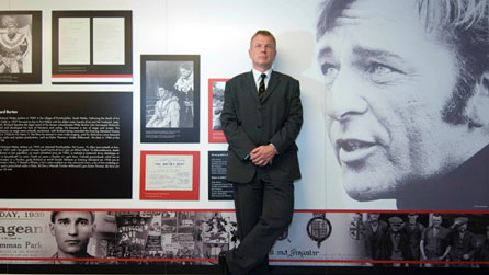Professor Chris Williams in front of a display of Richard Burton pictures and documents. Photo courtesy of Swansea University.