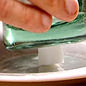 A sugar cube is crushed with a glass.