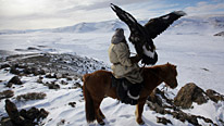 A Kazakh hunter with the golden eagle he has trained to hunt foxes