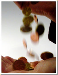 Picture of coins being dropped from a hand.