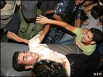Cameraman da Reuters Fadel Shana é levado ferido do local do ataque