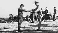 A Japanese army captain surrenders his sword to an American officer on Saipan