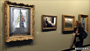 Woman looking at Monet paintings at an exhibition in Grand Palais, Paris