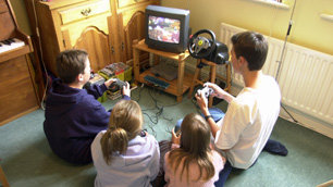A group of teenagers playing a Playstation game.