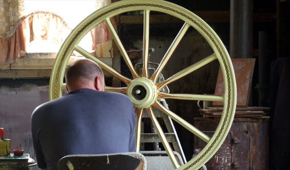 James Brindley painting a Gypsy wagon wheel