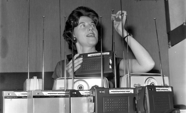 A woman looks a selection of transistor radios. (Photo: Getty Images)