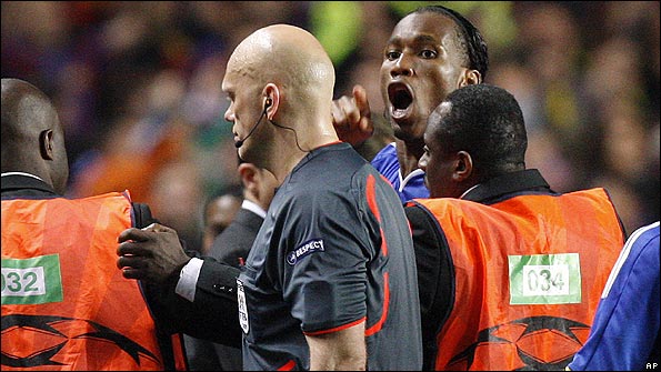Drogba has to be restrained by stewards from confronting the referee