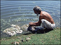 man washing clothes in the river
