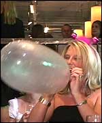 Woman blowing up a balloon