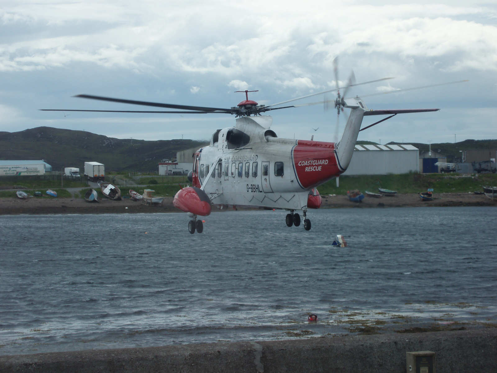 Helicopter over Newton Basin. The overturned boat can be seen to its right. 
