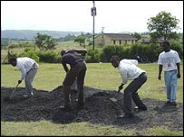 Two pupils from the school and two community volunteers, working during the lunch time to level out the schools roads after the rain