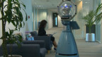 A woman sitting in a chair, next to a robot
