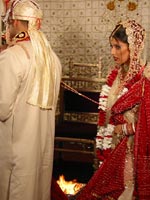 Bride and groom walking around the fire