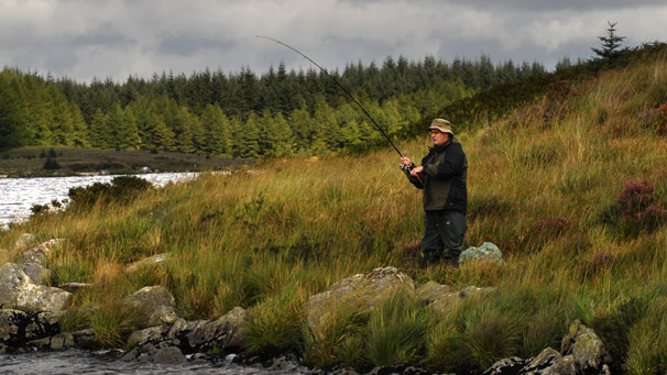 Man fishing at loch edge