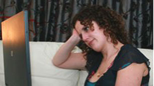 Kaliya Franklin holding her head in her hands as she checks out Facebook on her laptop