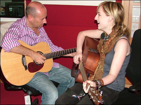 Kristy teaching Mark the guitar