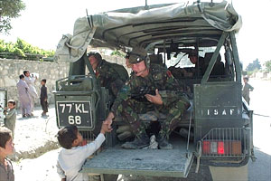 Local children come to shake hands with the patrolling British peace-keeping troops
