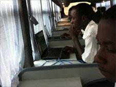 People using computers on bus