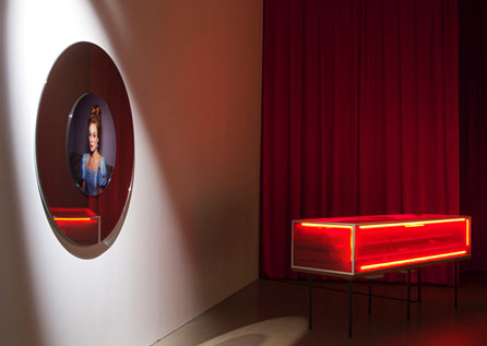 Miriam Bäckström, Attractions/Red Vitrine (2010). Coloured (red) vitrine in glass and wood, with interior made of wood and coloured mirrors, neon light (red) with electric support. Four black painted iron legs. Objects placed in the interior, on the mirrors.
