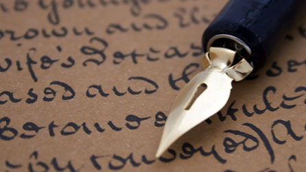 Photograph of a pen resting on a page of old writing
