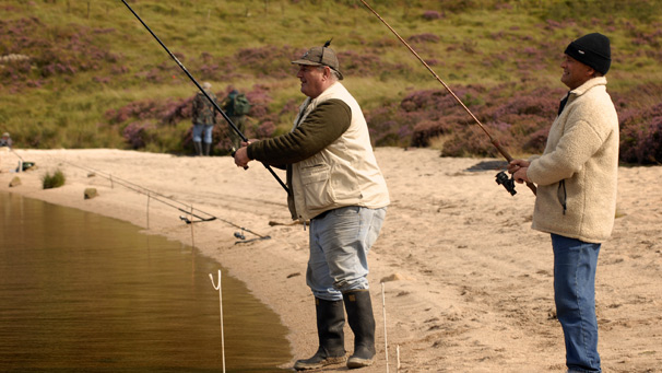 Two men fishing from sandy beach
