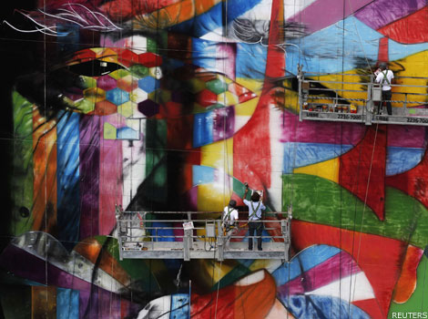Graffiti artist Eduardo Kobra putting the finishing touches on an art tribute to architect Oscar Niemeyer.
