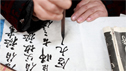 Hand holding Chinese brush pen writing Chinese characters © zhudifeng - Fotolia.com