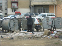 Një njeri duke rrëmuar nëpër kazana plehrash