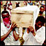 Rwandan refugees bearing a coffin