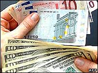 Một người phụ nữ cầm đồng dollar và đồng euro