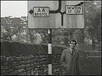 Reporter below a road sign