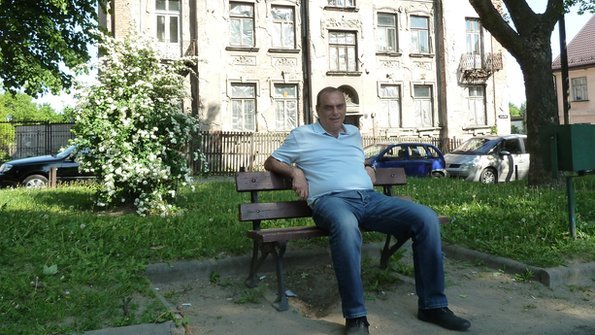 Avram Grant sitting on a bench outside his grandfather's house