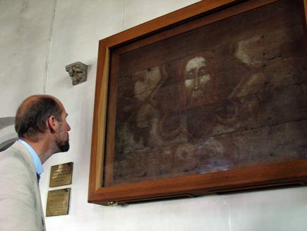 Martin Palmer views a painting on the wall of Templecombe Preceptory. The painting is dark and looks faint from age, but a saintly or Christlike male face is visible in the centre